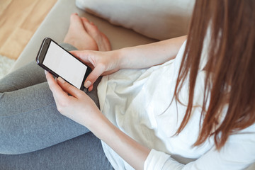 The girl lies on a sofa with a phone in his hand. Online shopping concept