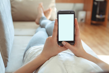 The girl lies on a sofa with a phone in his hand. Online shopping concept