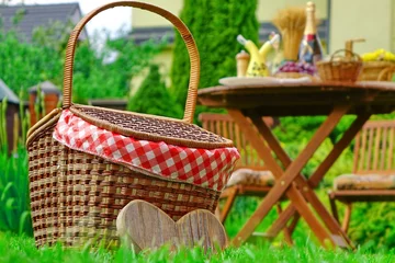 Fotobehang Picknick Close-up van picknickmand met geruite doek op het gazon