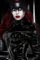 Red haired woman with weird black makeup in latex clothes