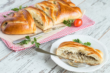  Pie with a fish.   Pie with a fish on a napkin and a piece of pie on a plate on a light wooden background.
