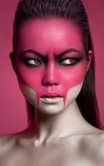 Attractive girl vampire with pink body art on face