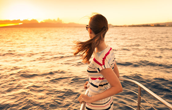 Woman relaxing on a yacht enjoying the beautiful sunset. 