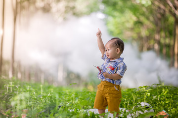 Naklejka premium thai baby playing on grass in park