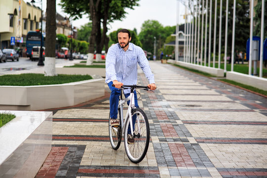 young hipster man with fixed gear bike on city street