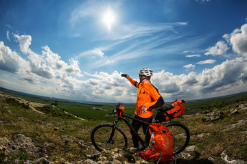 Cyclist taking picture with smart phone.