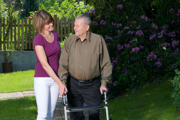 Senior mit Rollator und Pflegekraft