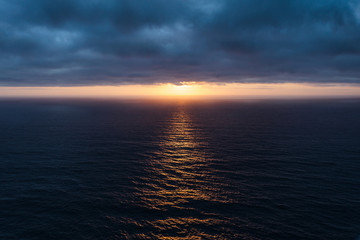 The sunlight pierced the dark blue clouds and lit up the Atlantic Ocean.