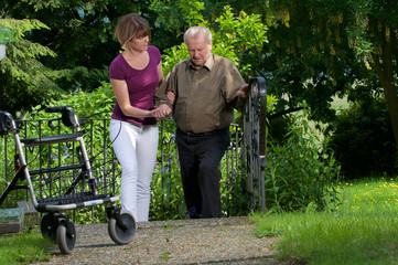 Senior mit Rollator und Pflegekraft