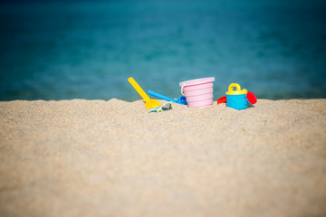 Fototapeta na wymiar Children's beach toys buckets spade and shovel on sand on sunny day