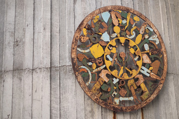 Obraz na płótnie Canvas old decoration on wooden wall rusty decoration circle decoration item antique decoration colorful decoration