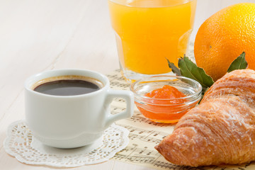 A cup of black coffee, croissant and orange juice. French breakfast