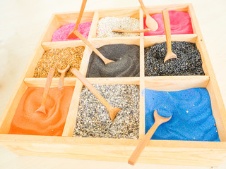 colorful sands and rocks in wooden box, art plant decoration in a glass pot by stones and sand Color