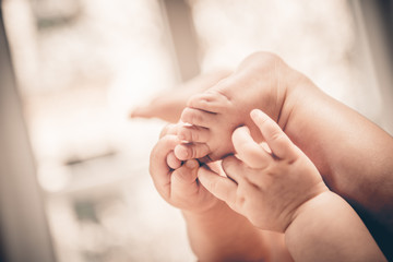 Baby holds his small hands their feet 