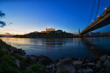 Fototapeta na wymiar The ancient castle in Bratislava, the Danube river and bridge at dusk, fisheye
