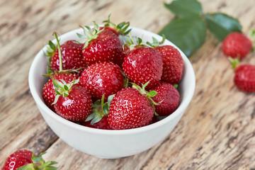 Bowl filled with juicy fresh ripe red strawberries. horizontal