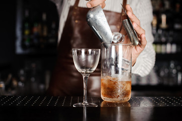 Bartender making cocktail at bar counter