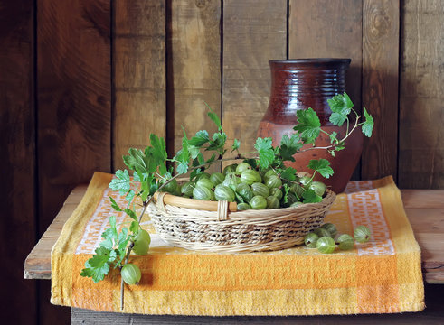 Still life with a basket of gooseberries and a jug.