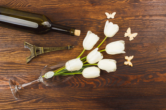 Wineglass with white tulips and bottle of wine