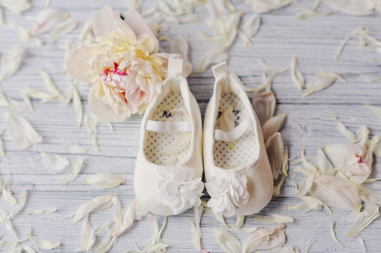 Милые беленькие туфельки  для маленькой девочки и нежный цветок