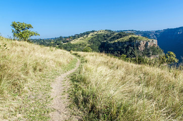 Fototapeta premium Hiking Trail in Nature Reserve with Rock Cliff Background