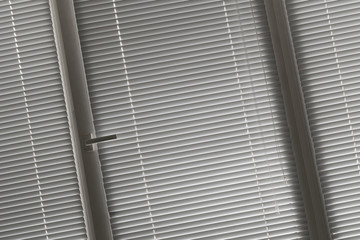 slanted view on grey horizontal jalousie in the office window