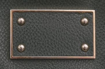 texture sample of the black imitation leather tag with metal border and rivets