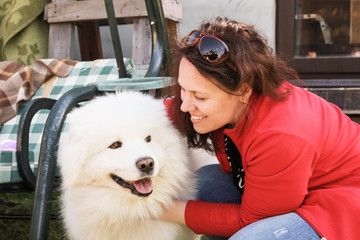 Young woman and white fluffy Samoyed dog