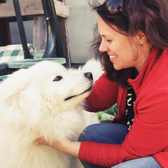 Happy young woman with white fluffy Samoyed dog