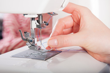 Woman threading on sewing machine