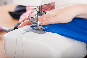 Young woman sewing fabric