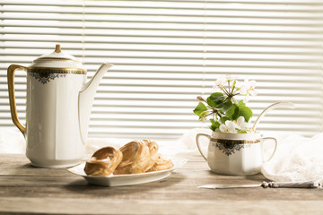 antique silver utensils, apple flowers and freshly baked pastries on a wooden table. vintage