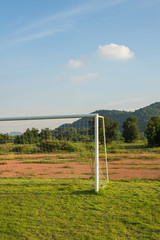 Soccer goal on field with mountain background.