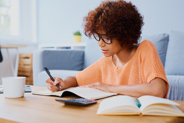 Busy young woman learning at home for exam