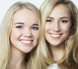 Two young girl friends standing together and having fun