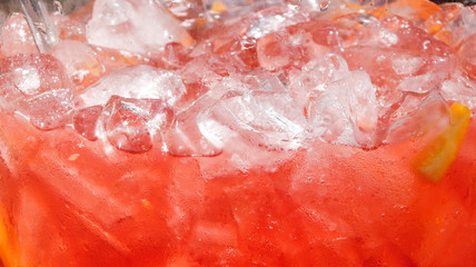 Background of red drink with lemon and ice.