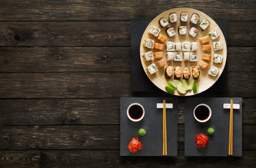 Set of sushi maki and rolls at rustic wood.