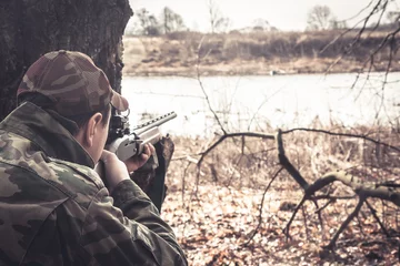 Photo sur Plexiglas Chasser Homme chasseur avec arme visant et prêt à tirer pendant la chasse