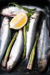 Obraz premium Fresh fish herring with spices, lemon and salt