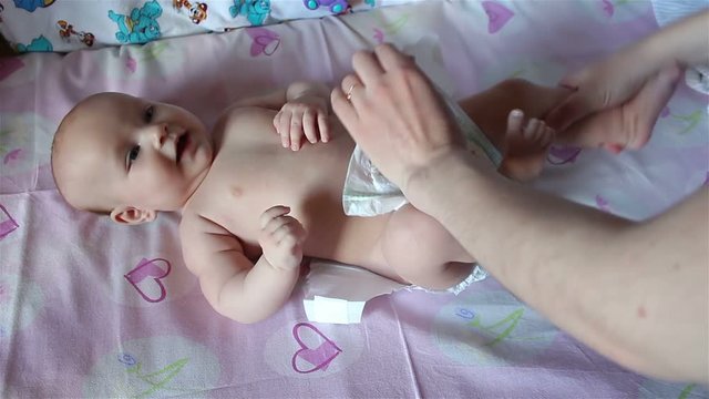Mom puts a diaper on the baby