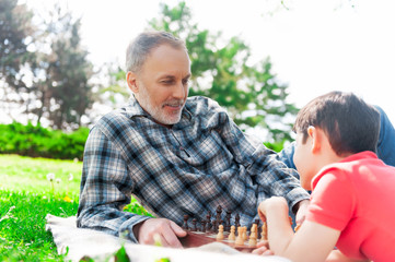 Cheerful grandparent is entertaining with his grandchild