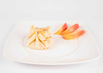 Pancake sack stuffed with braised apples decorated with apple slices