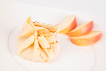 Pancake sack stuffed with braised apples decorated with apple slices