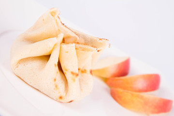 Pancake sack stuffed with braised apples decorated with apple slices