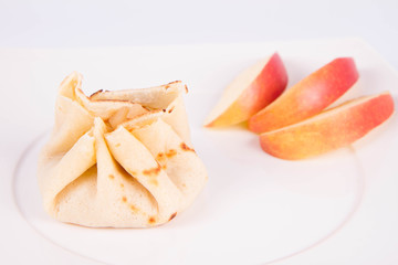 Pancake sack stuffed with braised apples decorated with apple slices