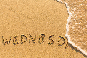 Wednesday -  word drawn on the sand beach with the soft wave.