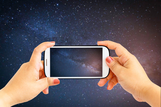 Smartphone photographing milky way galaxy with stars and space dust in the universe