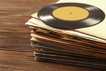 Stack of old vinyl records on wooden background