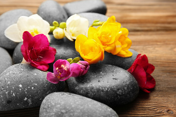 Obraz na płótnie Canvas Beautiful spa composition with stones and freesia on wooden background