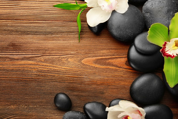 Fototapeta na wymiar Beautiful spa composition with stones and orchids on wooden background